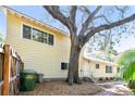 Sunlit side view of home, showcasing a neat yard, ample windows, and beautiful oak tree at 3001 Bay Shore Cir, Sarasota, FL 34234