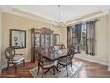 Formal dining room with a wood table, china cabinet, chandelier and sunlit window at 306 Country Meadows Way, Bradenton, FL 34212