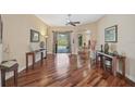 Open-concept living room with hardwood floors, neutral tones, and backyard views through sliding glass doors at 306 Country Meadows Way, Bradenton, FL 34212