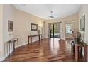 Bright living room featuring hardwood floors, neutral walls, and sliding glass doors leading to the pool area at 306 Country Meadows Way, Bradenton, FL 34212