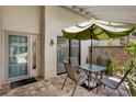 Inviting outdoor patio space with a table, chairs, and a green umbrella at 3362 Sandleheath # 12, Sarasota, FL 34235