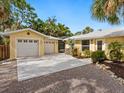 Spacious driveway leads to a two-car garage, complemented by lush landscaping at 4830 Estrada De Costa, Sarasota, FL 34242