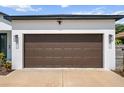 The home has a two-car garage with a dark brown door and modern exterior lighting at 4920 69Th N St, St Petersburg, FL 33709