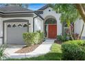 Close up of a house featuring a red front door and a well manicured green lawn at 5103 Twin Creeks Dr, Valrico, FL 33596