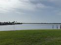 Scenic waterfront view featuring lush green grass and calm water, perfect for enjoying nature's tranquility at 5111 Bay State Rd, Palmetto, FL 34221