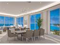 Bright great room with dining table and chairs, stunning ocean view, modern light fixture and neutral decor at 555 Quay Cmn # 2004, Sarasota, FL 34236