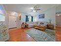 Cozy living room with wood floors, ceiling fan, and plenty of natural light at 590 Ridgewood Nw St, Port Charlotte, FL 33952