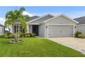 Well-kept single-story home with a two-car garage, featuring a tidy lawn and verdant landscaping, perfect for curb appeal at 5958 164Th E Ave, Parrish, FL 34219