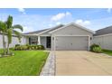 Inviting single-story home with a two-car garage, showcasing lush landscaping and a well-maintained lawn on a sunny day at 5958 164Th E Ave, Parrish, FL 34219