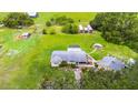 Expansive aerial view of a home with a screened-in pool and vast green land at 5981 Jim Davis Rd, Parrish, FL 34219