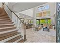 Open-concept living area boasts high ceilings, staircase, and travertine flooring at 6306 Anise Dr, Sarasota, FL 34238