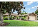 Inviting home exterior with mature trees, manicured lawn, and charming stone accents at 7401 3Rd Nw Ave, Bradenton, FL 34209