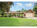 Charming single-story home with a well-manicured lawn and tropical landscaping at 7401 3Rd Nw Ave, Bradenton, FL 34209