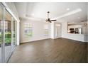 Spacious living room features wood floors, a modern ceiling fan, and sliding doors at 7403 Hamilton Rd, Bradenton, FL 34209