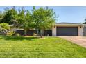 Charming home showcasing a well-manicured lawn and a gray two-car garage at 7442 N Leewynn Dr, Sarasota, FL 34240
