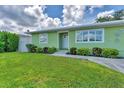 Well-maintained yard and landscaping leads up to the front of this charming, light green home at 7727 9Th Avenue Nw Dr, Bradenton, FL 34209