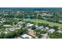 Aerial view of property featuring golf course and lake views, surrounded by lush trees at 7952 Hampton Ct, University Park, FL 34201