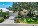 Inviting single-story home featuring a well-maintained lawn, attached garage, and beautiful mature landscaping at 7952 Hampton Ct, University Park, FL 34201