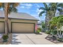 Inviting home featuring a well-maintained lawn, tropical landscaping, and a spacious two-car garage at 8579 54Th Avenue E Cir, Bradenton, FL 34211
