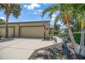 Charming home featuring tropical landscaping, a two-car garage, and a well-maintained driveway at 8579 54Th Avenue E Cir, Bradenton, FL 34211