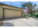 Home showcasing a clean driveway, tropical landscaping, and an American flag at 8579 54Th Avenue E Cir, Bradenton, FL 34211