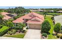 Charming home featuring a red tile roof, a two-car garage, and lush landscaping in a well-maintained yard at 8906 Stone Harbour Loop, Bradenton, FL 34212