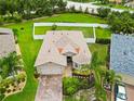 Beautiful home on a manicured lawn featuring mature landscaping and a paver driveway at 8937 Excelsior Loop, Venice, FL 34293