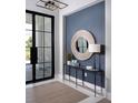 Stylish foyer featuring a console table, round mirror, and modern lighting at 1162 Blue Shell Loop, Sarasota, FL 34240
