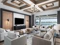 Modern living room boasting coffered ceilings, stylish furniture, and a view of the pool and lake at 1162 Blue Shell Loop, Sarasota, FL 34240