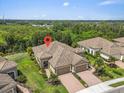 Aerial view of a single-Gathering home featuring a beautiful tile roof and meticulously maintained landscaping at 1301 Backspin Dr, Englewood, FL 34223