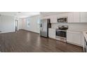Open-concept kitchen with stainless appliances, white cabinets, and modern flooring at 13125 Bayberry Way, Parrish, FL 34219