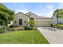 Well maintained single-story home featuring a manicured lawn, two-car garage, and beautiful landscaping at 15316 Shady Palms Ln, Nokomis, FL 34275