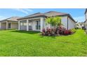 Expansive backyard featuring well-manicured lawn, lush landscaping and a covered patio with brick pavers at 17333 Savory Mist Cir, Bradenton, FL 34211