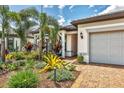 Beautifully landscaped front entrance with colorful plants and a brick walkway at 17910 Waterville Pl, Lakewood Ranch, FL 34202