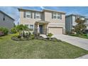 Charming two-story home with a manicured lawn, stone accents, and an attached two-car garage at 2136 Midnight Pearl Dr, Sarasota, FL 34240
