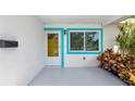 Inviting front porch with a bright yellow door, modern mailbox, and colorful plants at 320 59Th W St, Bradenton, FL 34209