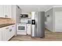Bright kitchen with stainless steel refrigerator, white cabinets, and modern appliances at 320 59Th W St, Bradenton, FL 34209