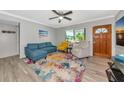Comfortable living room with a colorful rug, a ceiling fan, and a view to the outside at 320 59Th W St, Bradenton, FL 34209