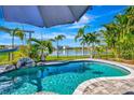 Inviting swimming pool with a lake view, palm trees, and blue skies at 3218 Big Sky Way, Bradenton, FL 34211