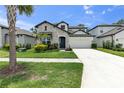 Charming two-story home featuring stone accents, a lush green lawn, and a well-manicured landscape at 3553 Secluded Ct, Sarasota, FL 34240
