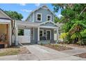 Charming blue two-story home with a welcoming front porch and a convenient carport at 412 E Amelia Ave, Tampa, FL 33602