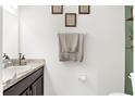 Clean powder room featuring a vanity with granite countertop, wall art, and neutral towels at 4644 Vignette Way, Sarasota, FL 34240