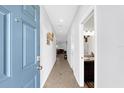Bright hallway leading to a powder room and living area; the doorway is painted the same blue as the front door at 4644 Vignette Way, Sarasota, FL 34240