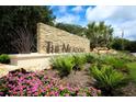 The Meadows community sign with stone accents, lush landscaping, and pink flowers at 4835 Winslow Beacon # 46, Sarasota, FL 34235