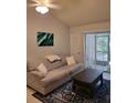 Comfortable living room with neutral tones, a ceiling fan, and sliding glass doors to the outside at 4835 Winslow Beacon # 46, Sarasota, FL 34235