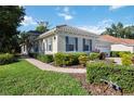 Attractive single-story home with blue shutters and trim, surrounded by mature landscaping and a patterned paver sidewalk at 5018 Hanging Moss Ln, Sarasota, FL 34238