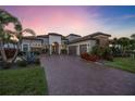 Luxury home showing landscaping and a paver driveway as well as a grass lawn at 5328 Brookgrove Dr, Sarasota, FL 34238