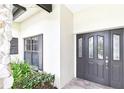 Close-up of a home's entrance, showing the front door, stone pillar, and nearby window at 6107 Misty Oaks St, Sarasota, FL 34243