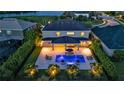 Night aerial view of a home featuring a backyard pool, covered patio, and lush landscaping at 6302 Anise Dr, Sarasota, FL 34238