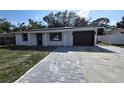 Charming single-story home with a gray paver driveway and a one-car garage at 6404 8Th Street W Ct, Bradenton, FL 34207